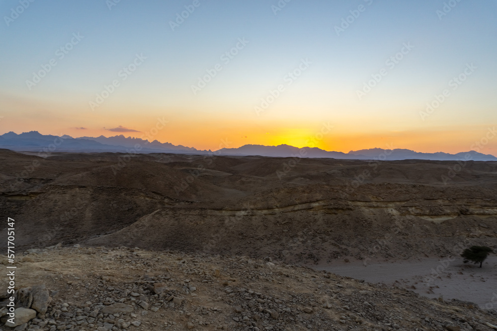 Sunset in the Hurghada desert, with the desert mountains on the horizon Sunset in the Hurghada desert, with the desert mountains on the horizon