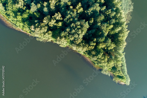 An island in a lake full of trees. A green island in the middle of a huge body of water. © Olivier Uchmanski