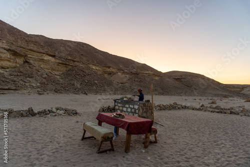 Man having a barbecue in a Bedouin village, in the Hurghada desert, at sunset