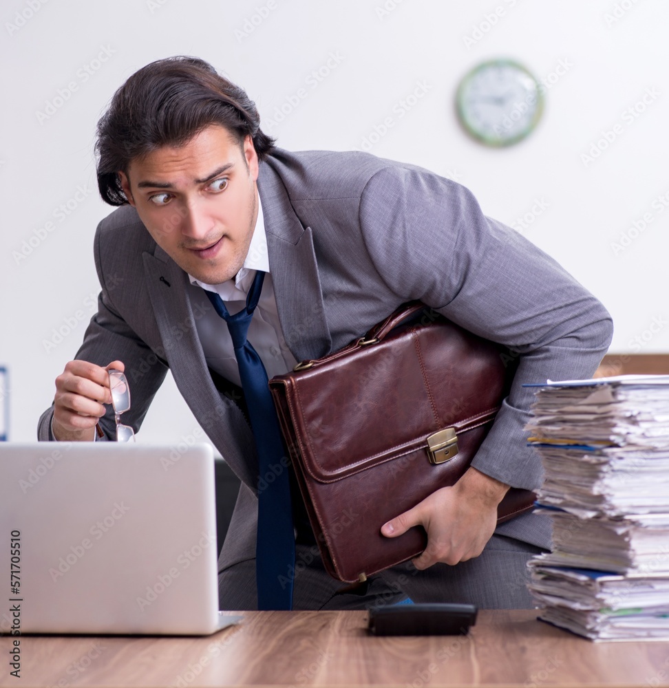 Young male employee unhappy with excessive work Young male employee unhappy with excessive work