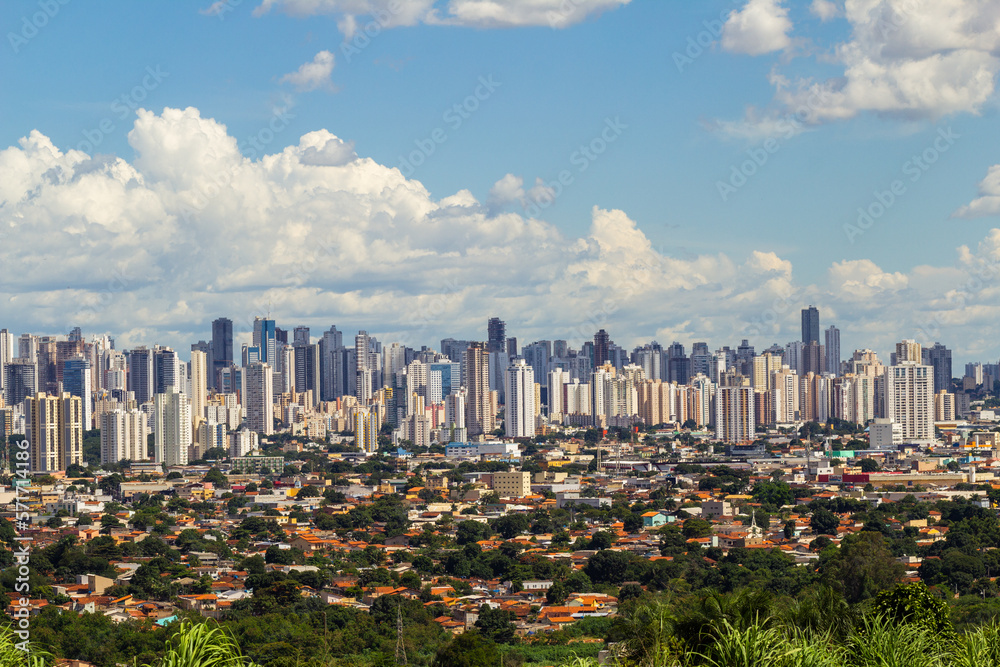 Cidade de Goiânia vista do Morro do Além, com muitos prédios e céu nublado ao fundo.