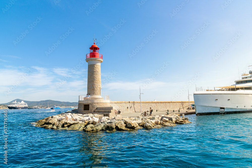 The St Tropez lighthouse at the edge of the pier and marina at the resort seaside town of St Tropez, France, along the Cote d'Azur French Riviera.