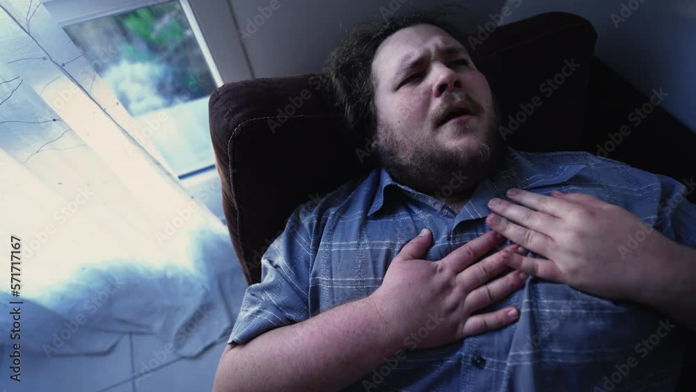 One fat man having heart problems laying on sofa at home suffering from chest pains. Dramatic health issues One fat man having heart problems laying on sofa at home suffering from chest pains. Dramatic health issues