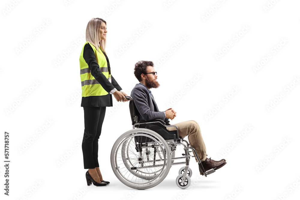 Female special assitance worker standing behind a man in a wheelchair Female special assitance worker standing behind a man in a wheelchair