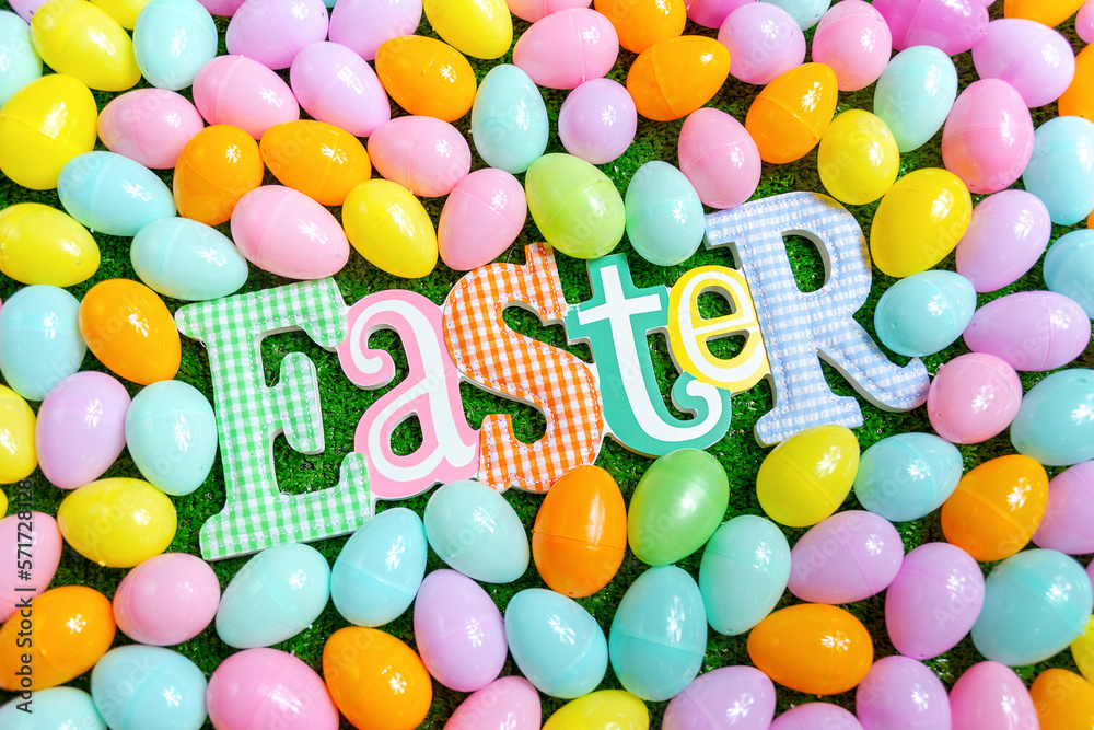 Easter word on a faux grass surrounded by plastic eggs Easter word on a faux grass surrounded by plastic eggs
