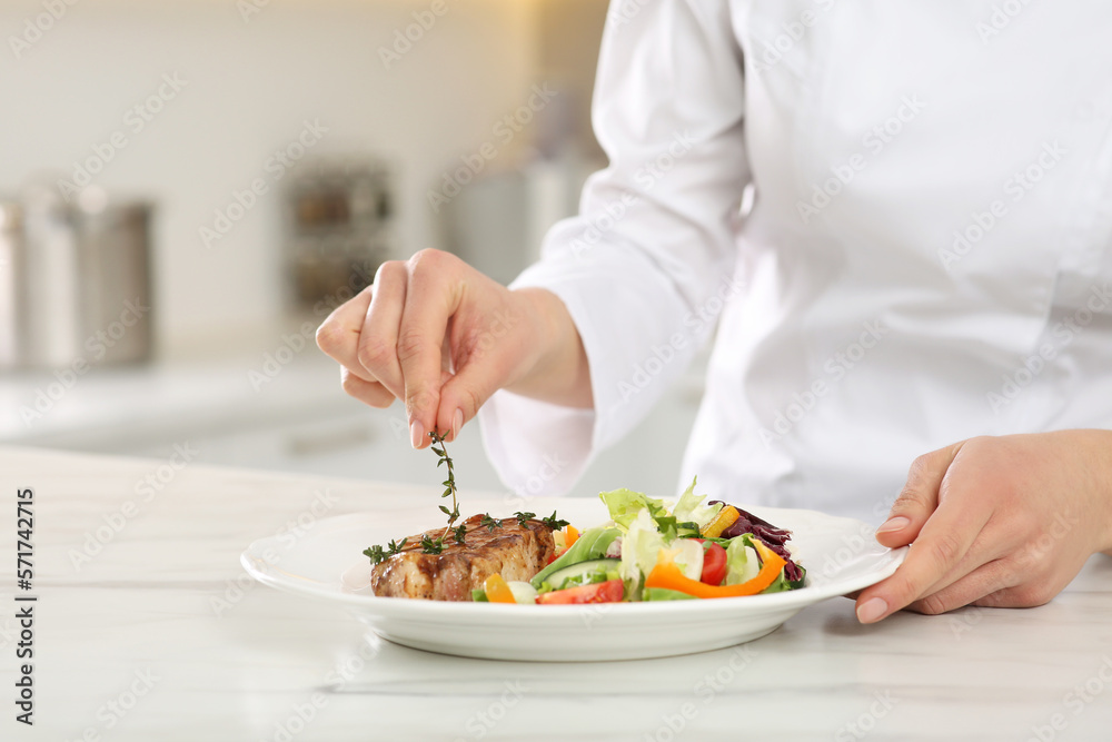 Professional chef decorating delicious dish with thyme at marble table, closeup. Space for text Professional chef decorating delicious dish with thyme at marble table, closeup. Space for text