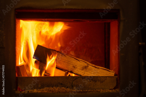 Close up of wooden logs burning in wood burning fire stove giving off warmth and heat.