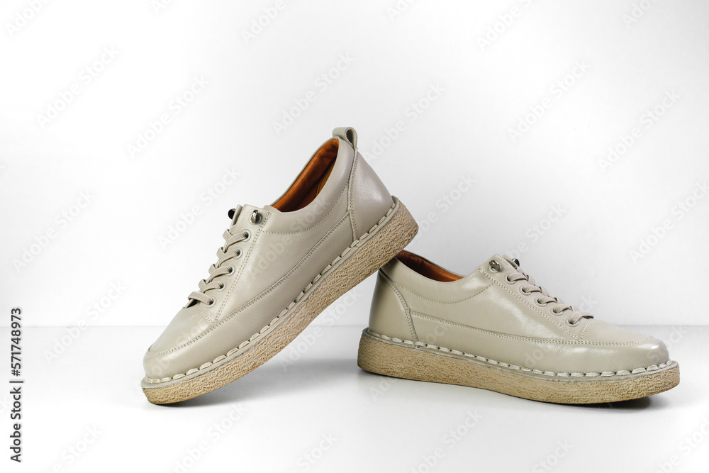 Beige Trendy Sneakers. Fashion shoes still life. Stylish photo boots in the studio.  casual shoes, fashion, footwear, shoe concept, retro, back to school.  - obrazy, fototapety, plakaty 