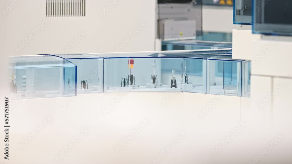 Long shot of many test tubes moving around on an automated lab line. Lab concept. High quality 4k footage