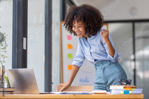 Excited african American woman sit at desk feel euphoric win online lottery, happy black woman overjoyed get mail at tablet being promoted at work, biracial girl amazed read good news at computer
