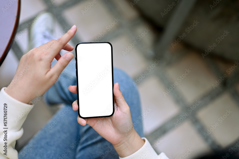 Top view of a woman sits at the backyard and uses her smartphone. phone white screen mockup Top view of a woman sits at the backyard and uses her smartphone. phone white screen mockup