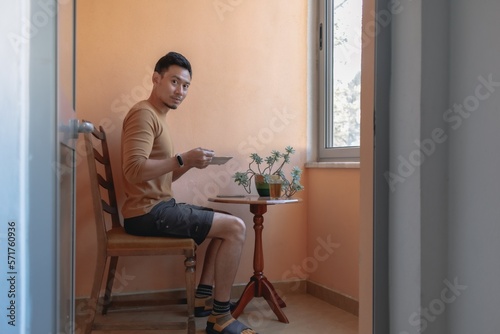 Asian man having breakfast soup on the terrace by the windows. © Sevendeman