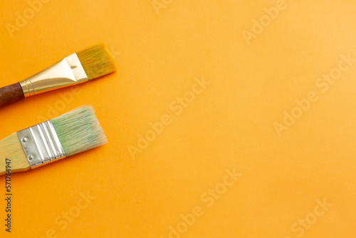 筆とブラシとオレンジ色の背景、美術向きの背景