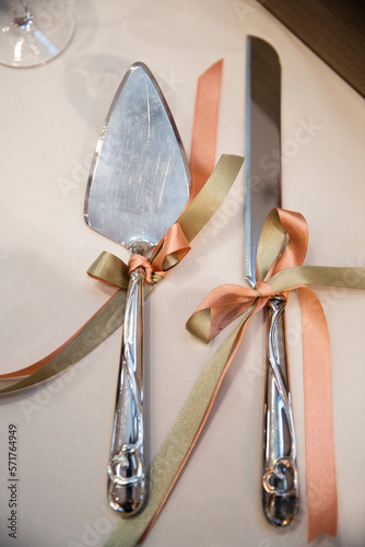 close up details of an autumn wedding reception featuring wedding cake servers decorated with hearts and orange peach and sage green bows