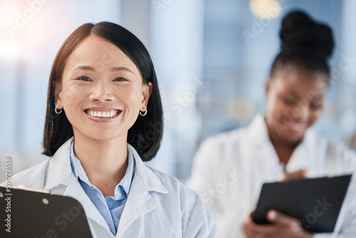 Asian doctor woman, checklist and portrait with smile, planning or happy at clinic with african expert. Medic, teamwork and clipboard for schedule, analysis or results in hospital for healthcare goal