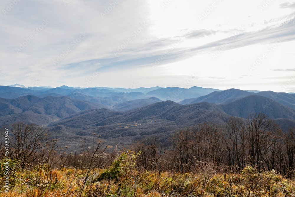 Landscape of a mountain range on an autumn morning. Panoramic view of the Caucasus mountains. View of the mountain range under a cloudy sky. Mountain landscape with beautiful Caucasian nature. 