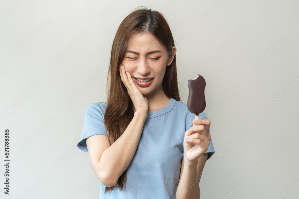 Face expression suffering from sensitive teeth and cold, asian young