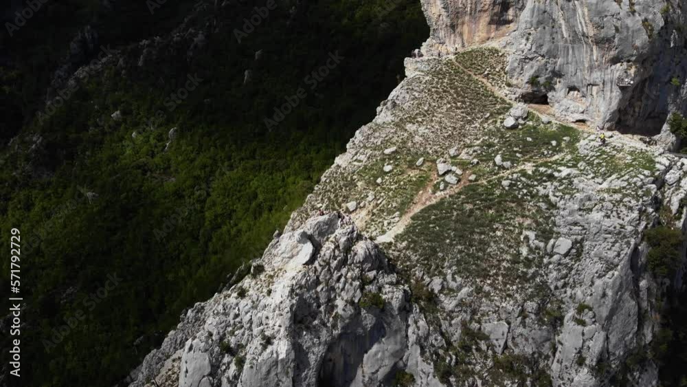 Unrecognizable people walking on top of mountain. Aerial circling, high angle Unrecognizable people walking on top of mountain. Aerial circling, high angle