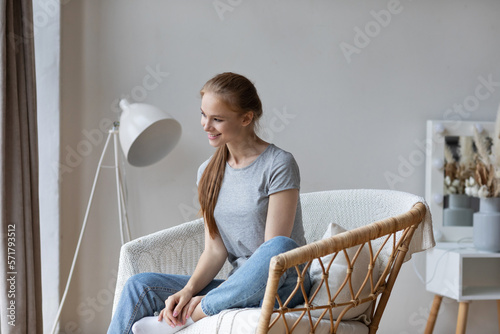 Dreamy happy woman sitting in a chair photo