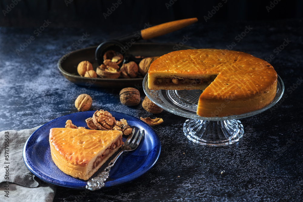 Engadine Walnuts Torte or Buendner Nusstorte on glass plate, a Swiss confectionery spacialty in Grisons - dark and moody