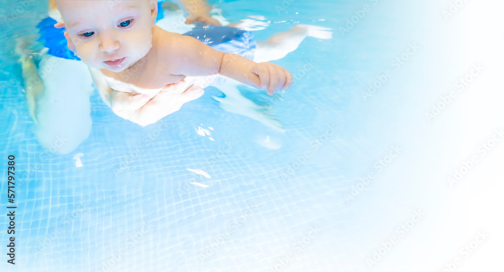 Adorable baby girl enjoying swimming in a pool with her mother early development class for