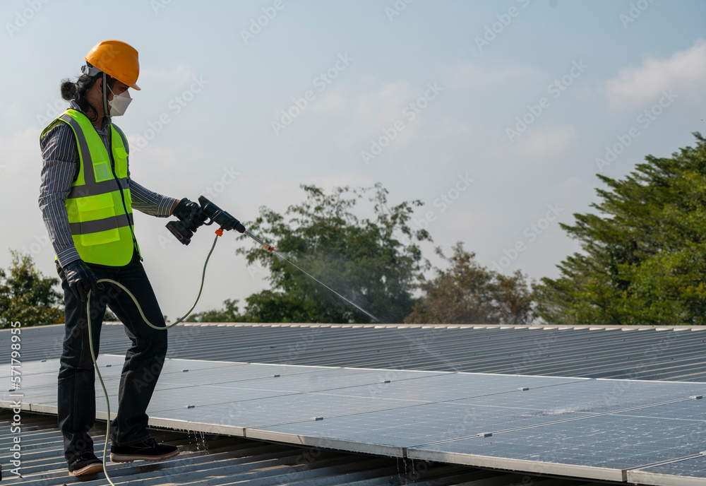 Maintenance technician using high pressure water to clean the solar panels that are dirty with dust to improve the efficiency of solar energy storage. Maintenance technician using high pressure water to clean the solar panels that are dirty with dust to improve the efficiency of solar energy storage.