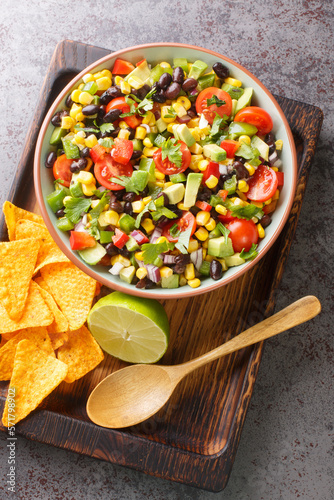 Cowboy texac caviar is a traditional American salad made with black beans, garlic, onion, bell peppers, jalapenos, corn, coriander closeup in the bowl on the table. Vertical top view from above photo