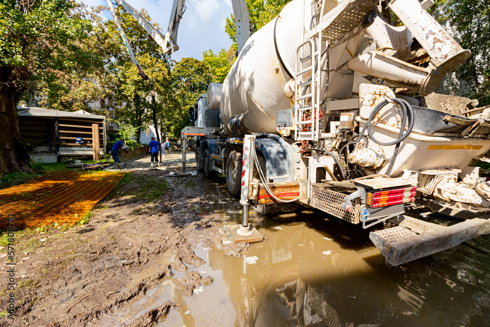 Concrete mixer at the construction site, pouring concrete from one mixer to other with pump for concrete Concrete mixer at the construction site, pouring concrete from one mixer to other with pump for concrete