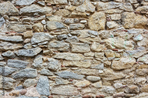 Stones of different shapes and sizes are built into the wall
