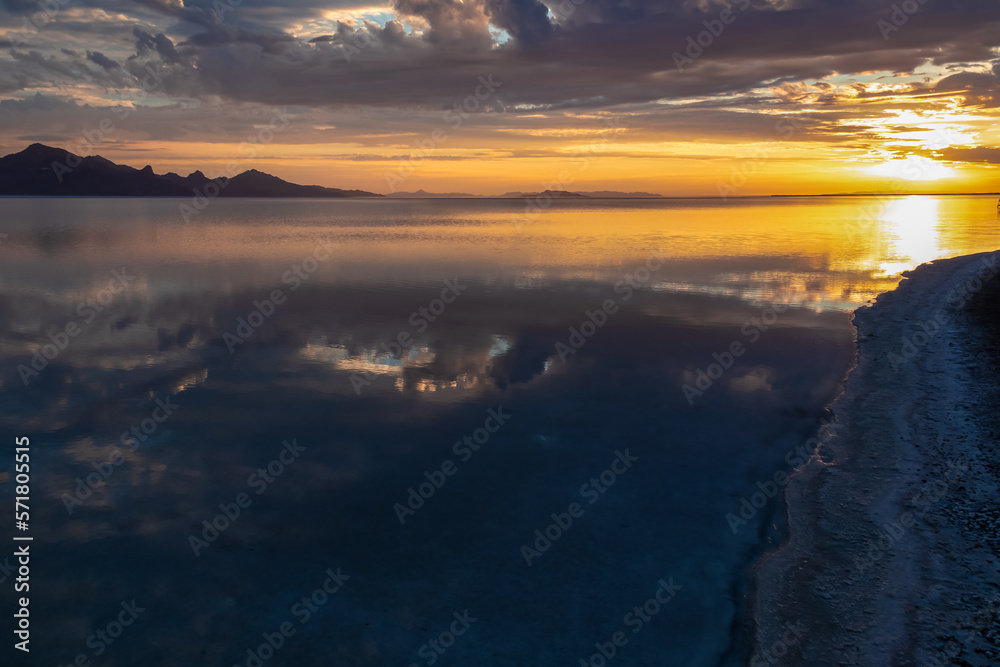 Scenic view of beautiful mountains reflecting in lake Bonneville Salt Flats after sunrise, Wendover, Western Utah, USA, America. Looking at summits of Silver Island Mountain range. Romantic atmosphere