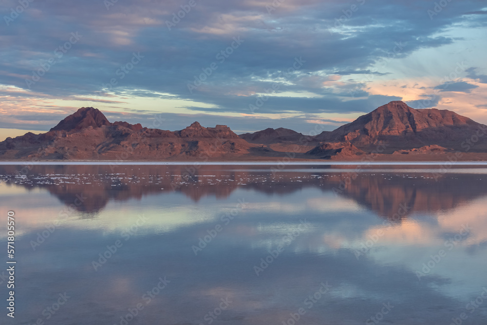 Scenic view of beautiful mountains reflecting in lake of Bonneville Salt Flats at sunrise, Wendover, Western Utah, USA, America. Looking at summits of Silver Island Mountain range. Romantic atmosphere