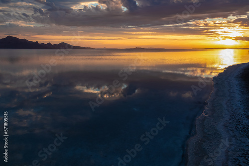 Scenic view of beautiful mountains reflecting in lake Bonneville Salt Flats after sunrise, Wendover, Western Utah, USA, America. Looking at summits of Silver Island Mountain range. Romantic atmosphere