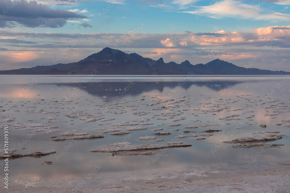 Scenic view of beautiful mountains reflecting in lake of Bonneville Salt Flats at sunset, Wendover, Western Utah, USA, America. Looking at summits of Silver Island Mountain range. Romantic atmosphere