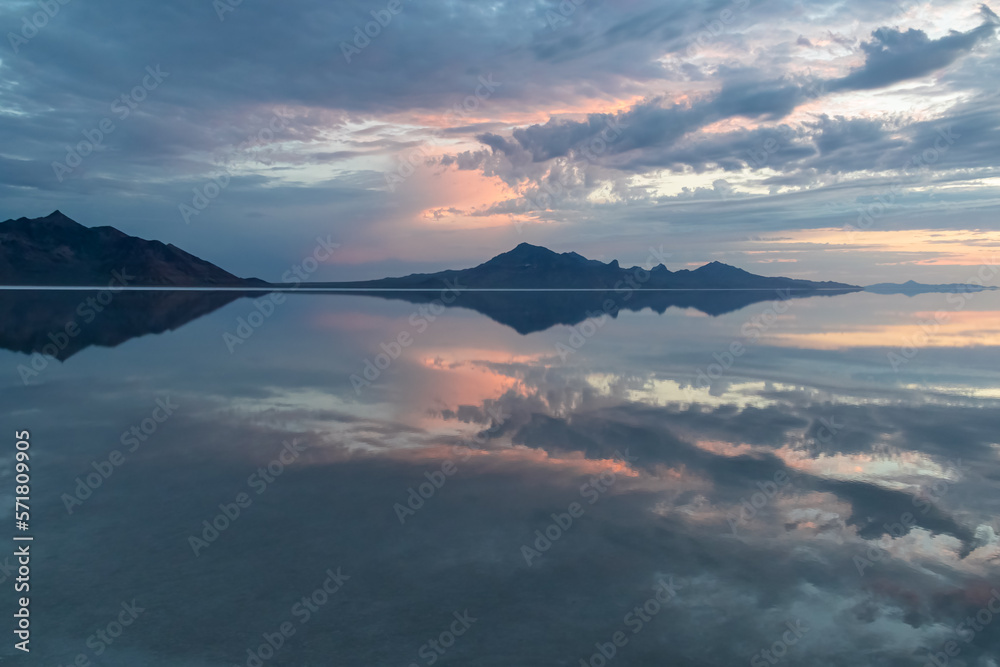 Scenic view of beautiful mountains reflecting in lake of Bonneville Salt Flats at sunrise, Wendover, Western Utah, USA, America. Looking at summits of Silver Island Mountain range. Romantic atmosphere