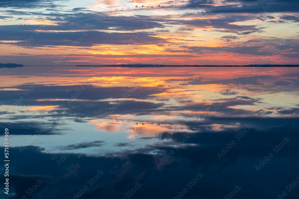 Scenic view of beautiful water reflections in lake of Bonneville Salt Flats at sunrise, Wendover, Western Utah, USA, America. Dreamy clouds mirroring on the water surface creating romantic atmosphere