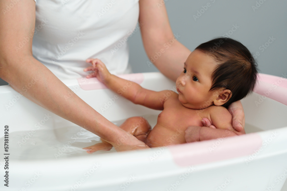 mother give a bath newborn baby in bathtub mother give a bath newborn baby in bathtub