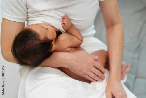 close up mother breastfeeding newborm baby on bed