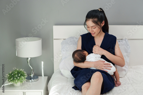 mother breastfeeding newborm baby on bed photo