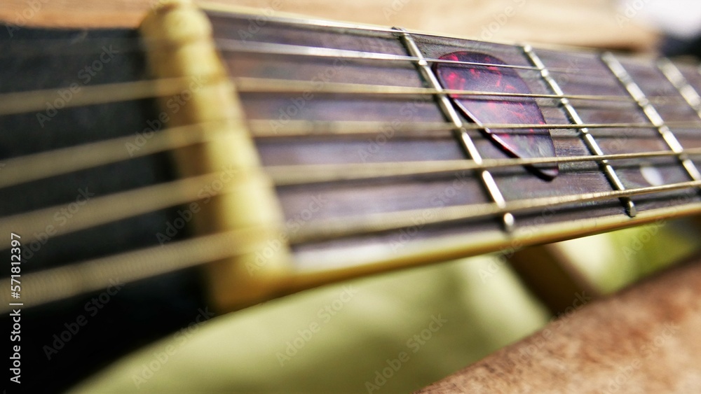 A close-up shot of an acoustic guitar. A pick on a guitar fretboard. Details of an old acoustic guitar. A guitar with rusty strings. A close-up shot of an acoustic guitar. A pick on a guitar fretboard. Details of an old acoustic guitar. A guitar with rusty strings.