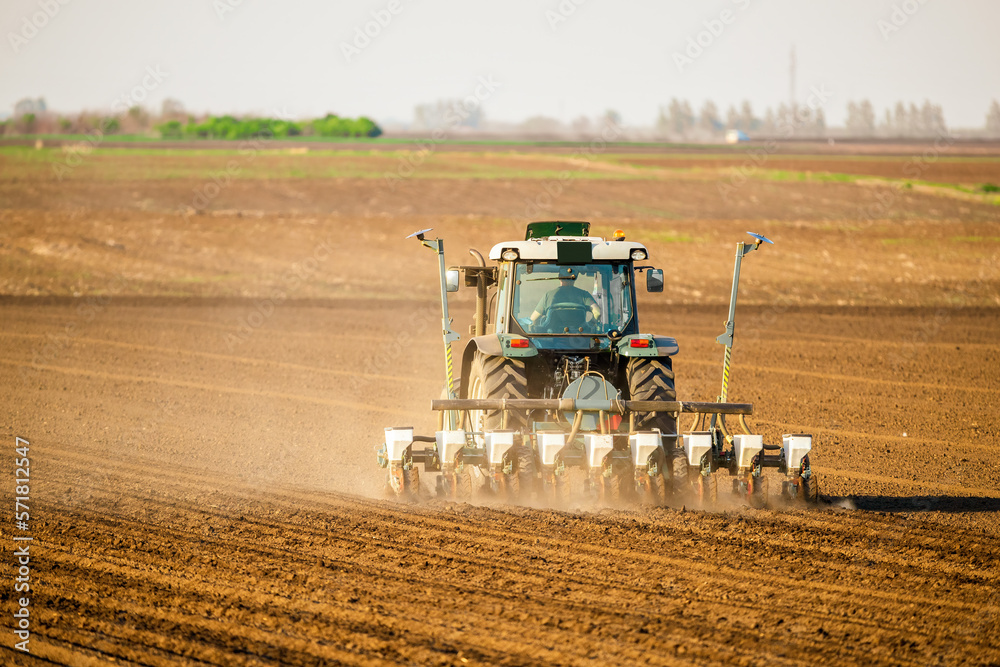 Obraz premium Farmer sowing soybean seeds in a field with modern equipment