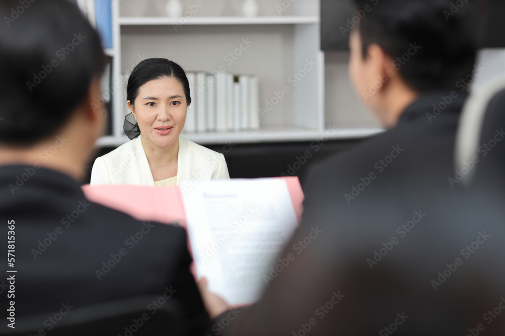 Human resources department managers sitting and interviewing female businesswoman applicant or candidate during job interview in modern office (Focus on female candidate). Business recruitment concept Human resources department managers sitting and interviewing female businesswoman applicant or candidate during job interview in modern office (Focus on female candidate). Business recruitment concept