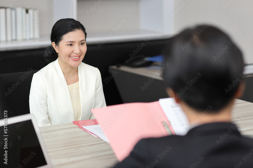 Human resources department managers sitting and interviewing female businesswoman applicant or candidate during job interview in modern office (Focus on female candidate). Business recruitment concept