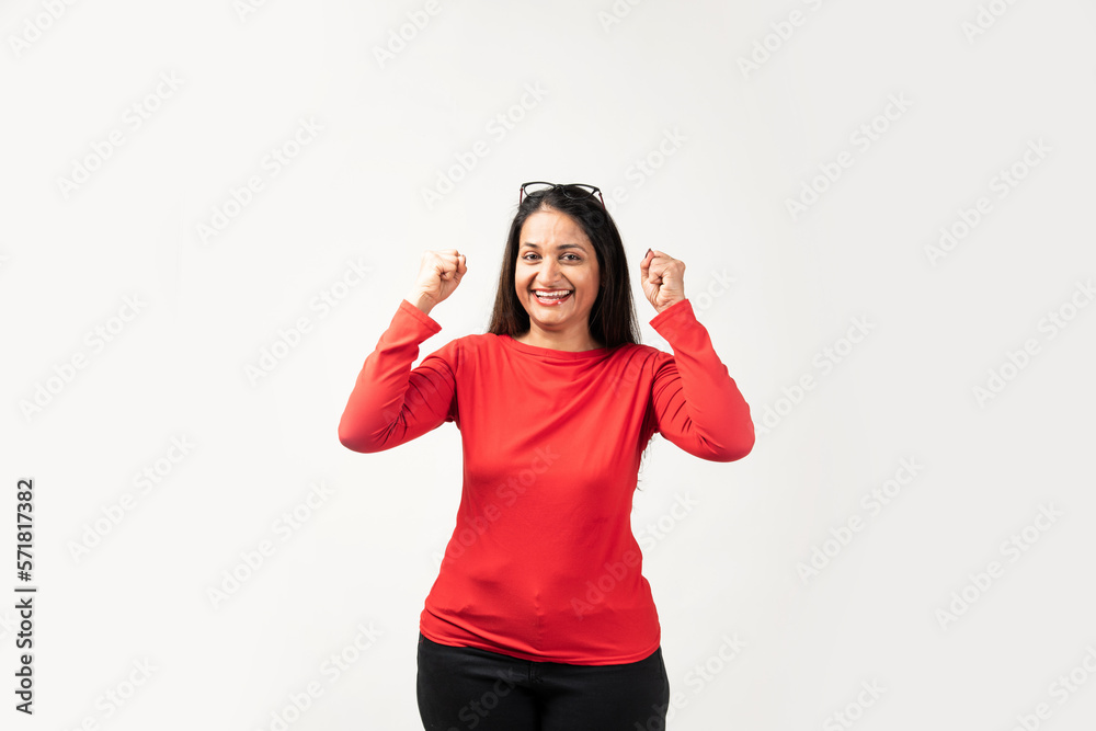 Confident Indian woman rejoicing, looking happy and celebrating victory, fist pump gesture Confident Indian woman rejoicing, looking happy and celebrating victory, fist pump gesture