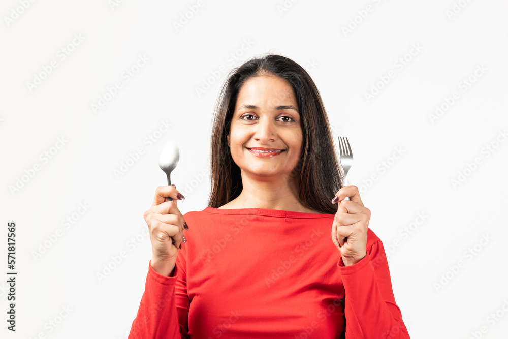 Indian thoughtful lady rising fork knife looking empty space isolated white color background
