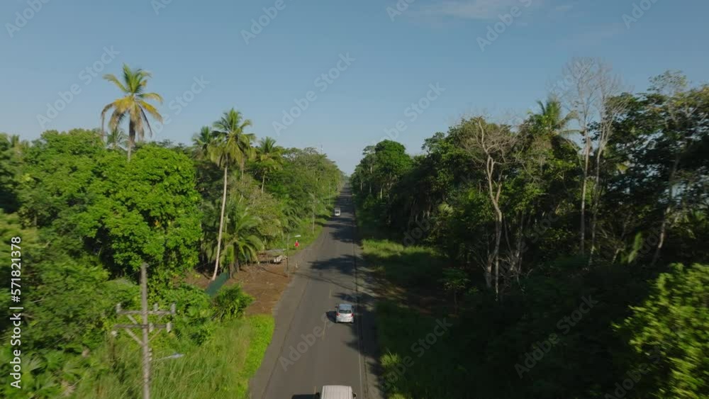 Tracking of vehicles overpassing slowly moving car of road leading through tropical forest. Costa Rica Tracking of vehicles overpassing slowly moving car of road leading through tropical forest. Costa Rica