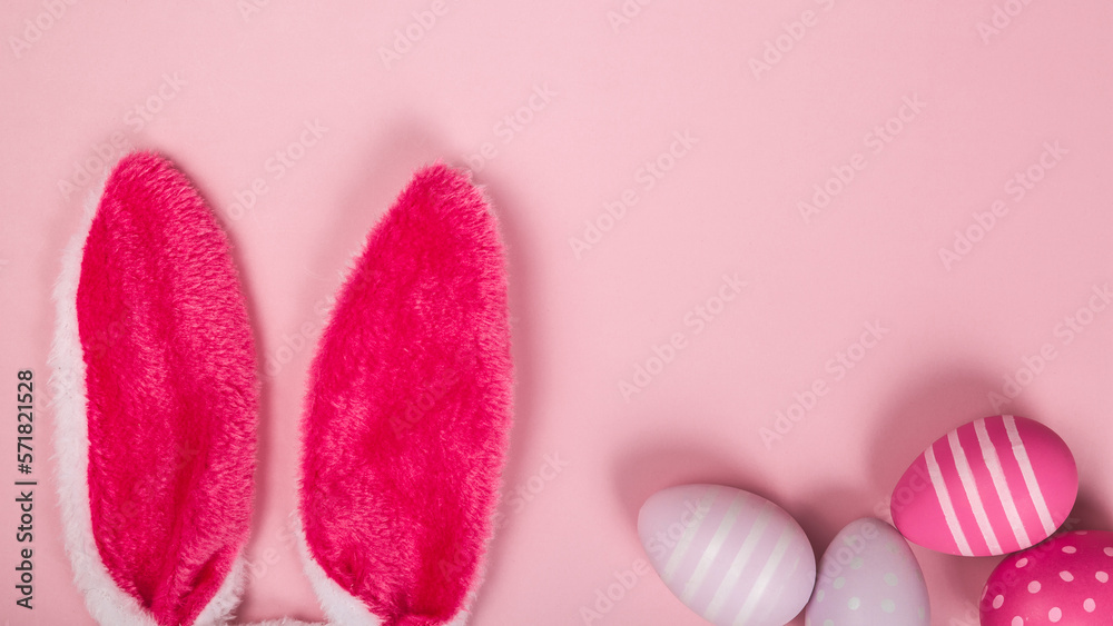 pink colored easter eggs and bunny ears on easter day on pastel background. celebrating easter. copy space