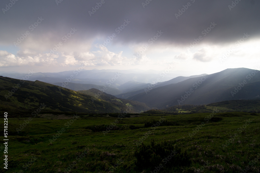 Low lying rain clouds above hill landscape photo. Beautiful nature scenery photography with highlands on background. Ambient light. High quality picture for wallpaper, travel blog, magazine, article