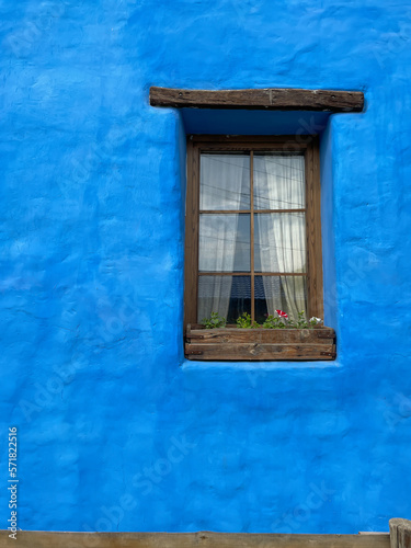 blue vintage wall with one window as background texture