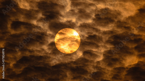 The beautiful closeup shot of the warm sun with clouds.
