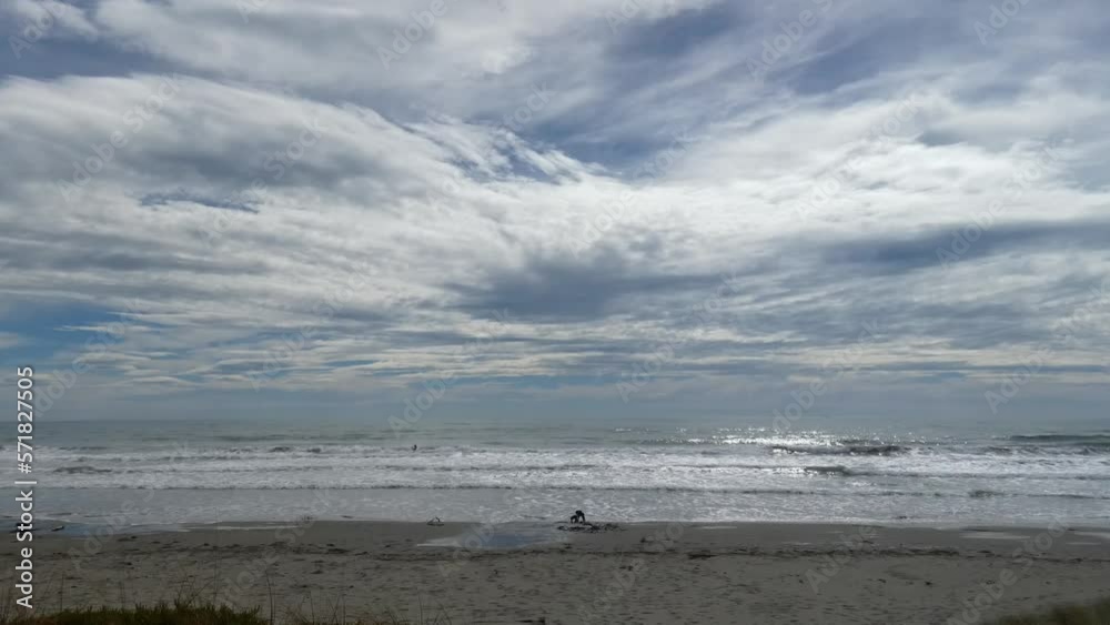 Summertime surfers appear tiny against backdrop of vast, interesting cloud patterns - New Brighton Beach (New Zealand) Summertime surfers appear tiny against backdrop of vast, interesting cloud patterns - New Brighton Beach (New Zealand)